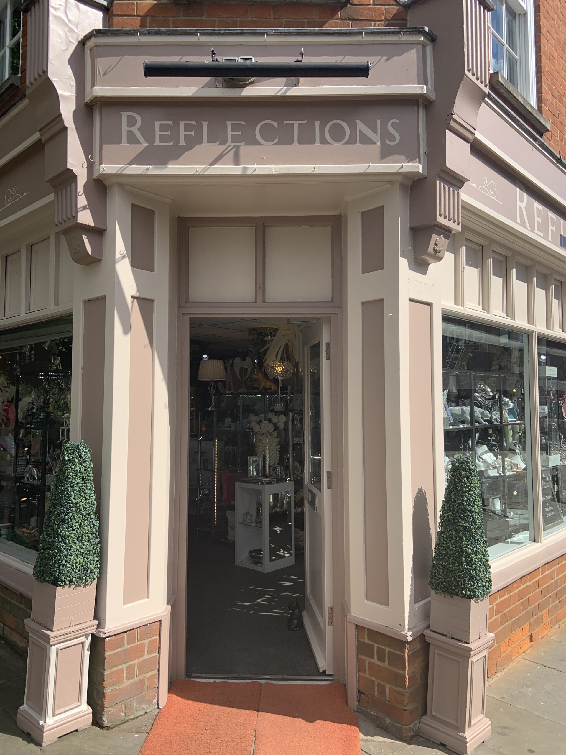 REFLECTIONS in Roman style lettters, hand painted shop fascia above the door 