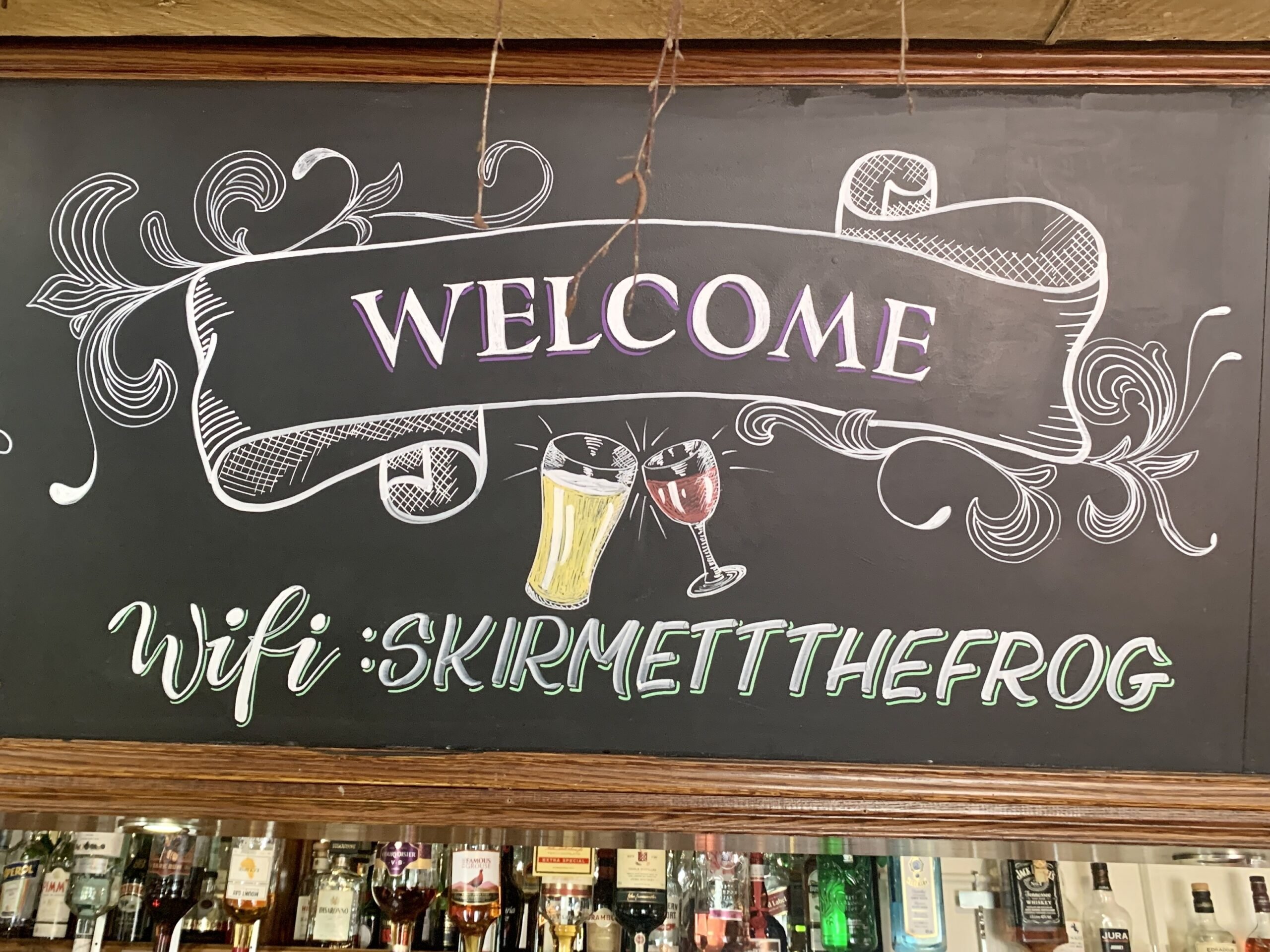 Hand-lettered hand-drawn blackboard over the bar sign for The Frog Inn at Skirmett, Henley-on-Thames