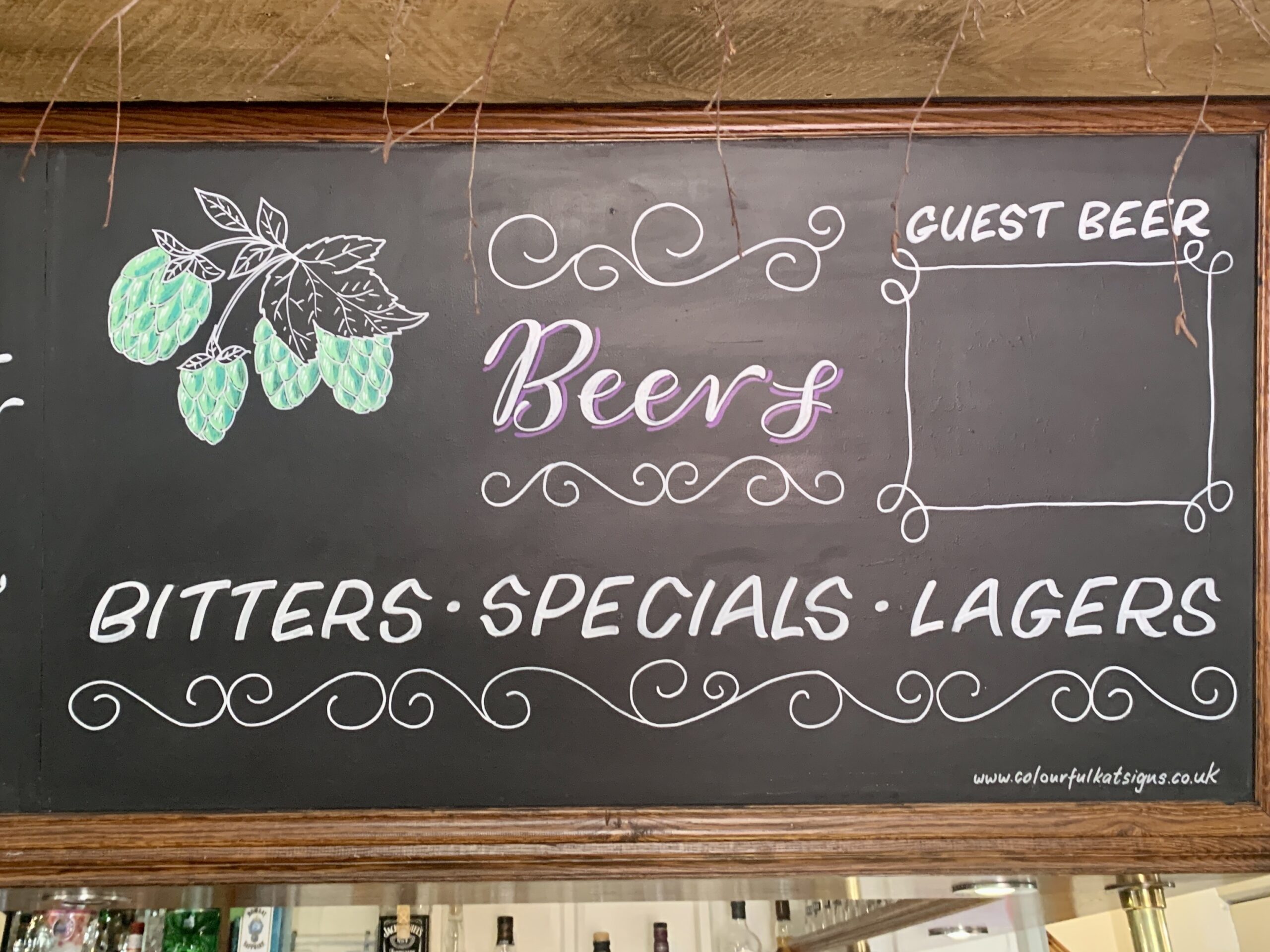 Hand-lettered hand-drawn blackboard over the bar sign for The Frog Inn at Skirmett